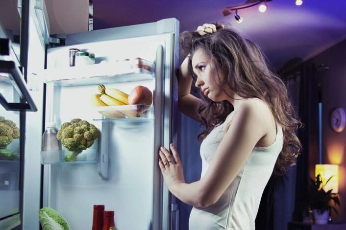 niña en el refrigerador mientras sigue su dieta favorita